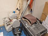 une photo d'une pièce en désordre avec un aspirateur et d'autres objets