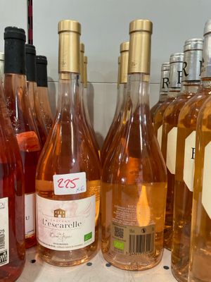 plusieurs bouteilles de vin sont alignées sur une étagère