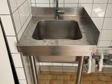un évier en acier inoxydable dans le coin d'une salle de bains