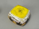 a small yellow and white box on a table next to a cup