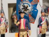 several figurines of men dressed in uniforms and holding flags