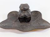 une petite statue représentant une personne assise sur une feuille