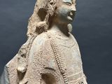 an old statue of a woman with a bird on her shoulder