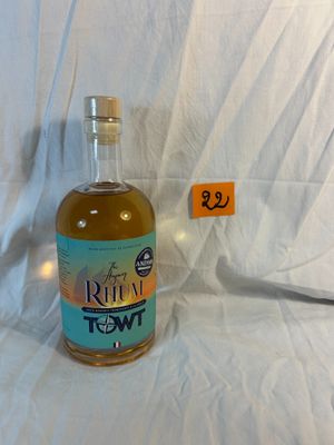 a bottle of liquor sitting on a bed with a price tag
