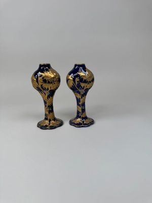 pair of blue and gold vases sitting on a white surface