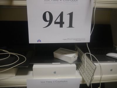 une pancarte posée sur une étagère sur laquelle se trouvent un clavier et une souris