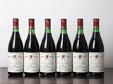 six bouteilles de vin rouge alignées sur une table en bois