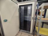 une porte blanche dans une pièce remplie d'étagères, les unes après les autres