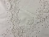 white table cloth with a lace edge and a flower design