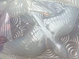 a glass bowl with a bird on it on a table