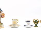une figurine représentant un homme avec un tambour, une tasse et une soucoupe