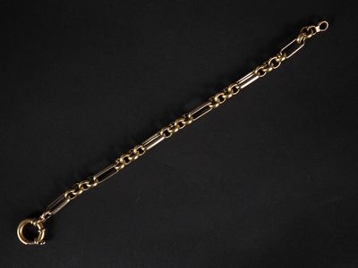 gros plan d'un bracelet en chaîne en or sur fond noir