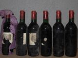 six bouteilles de vin sont alignées sur une table