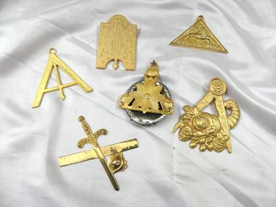 plusieurs types différents d'insignes en métal doré sur un tissu blanc