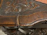 a close up of a wooden table with a red and gold tablecloth
