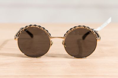 a close up of a pair of sunglasses on a wooden surface