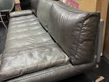 a couch that is sitting in a room with many boxes