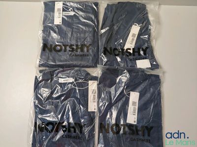 quatre t-shirts pour hommes dans des sacs en plastique posés sur une table