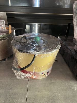 un seau de nourriture posé par terre devant une cuisinière