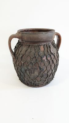 a brown vase that is sitting on a white surface