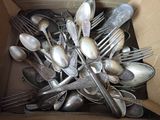 a lot of silver spoons and forks in a box