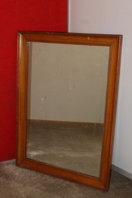 a mirror sitting next to a red wall in a room