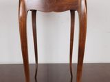 a small wooden table with a glass top on a wooden floor