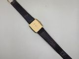 une montre plaquée or avec un bracelet en cuir noir