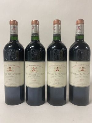 four bottles of wine are lined up on a white surface