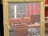 un miroir posé sur le sol devant une chaise