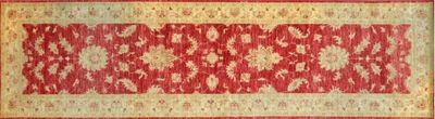 a close up of a red and beige rug on a wooden floor