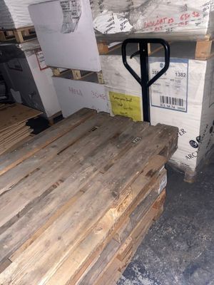 plusieurs palettes de bois sont empilées sur des palettes dans un entrepôt
