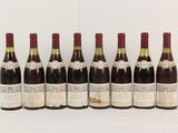 six bottles of wine are lined up in a row on a table
