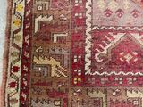 an old rug with a red and beige design on a blue floor