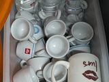 de nombreuses tasses et soucoupes dans un récipient posé par terre