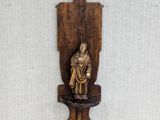 a wooden sculpture of a man on a shelf