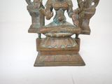 a bronze statue of a woman sitting on top of a table