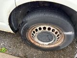 a dirty tire on the side of a white truck
