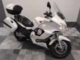 une moto blanche garée sur un sol à damier