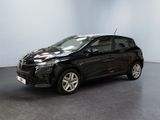 Une voiture noire est garée dans une pièce aux murs blancs.