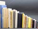 un chat noir assis à côté d'une pile de livres