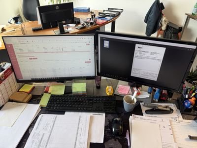 un bureau équipé de deux écrans et d'un clavier
