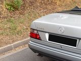 a silver car driving down the road with its roof down