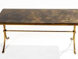 an antique brass coffee table with a marble top