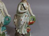 two figurines of a woman and a child with a bird