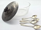 five spoons and a bowl of water next to each other