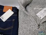 two pairs of jeans and a sweater with a price tag on them