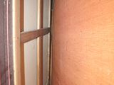 a window in the corner of a room with a curtain on it