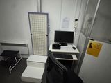 a desk with a computer and a chair in a room