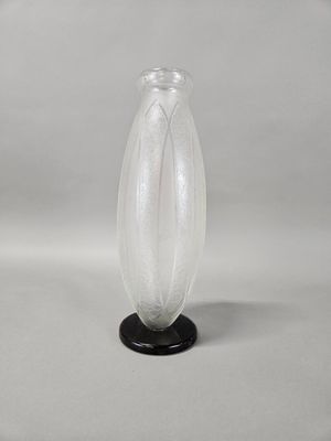 a clear glass vase with a black base on a white background